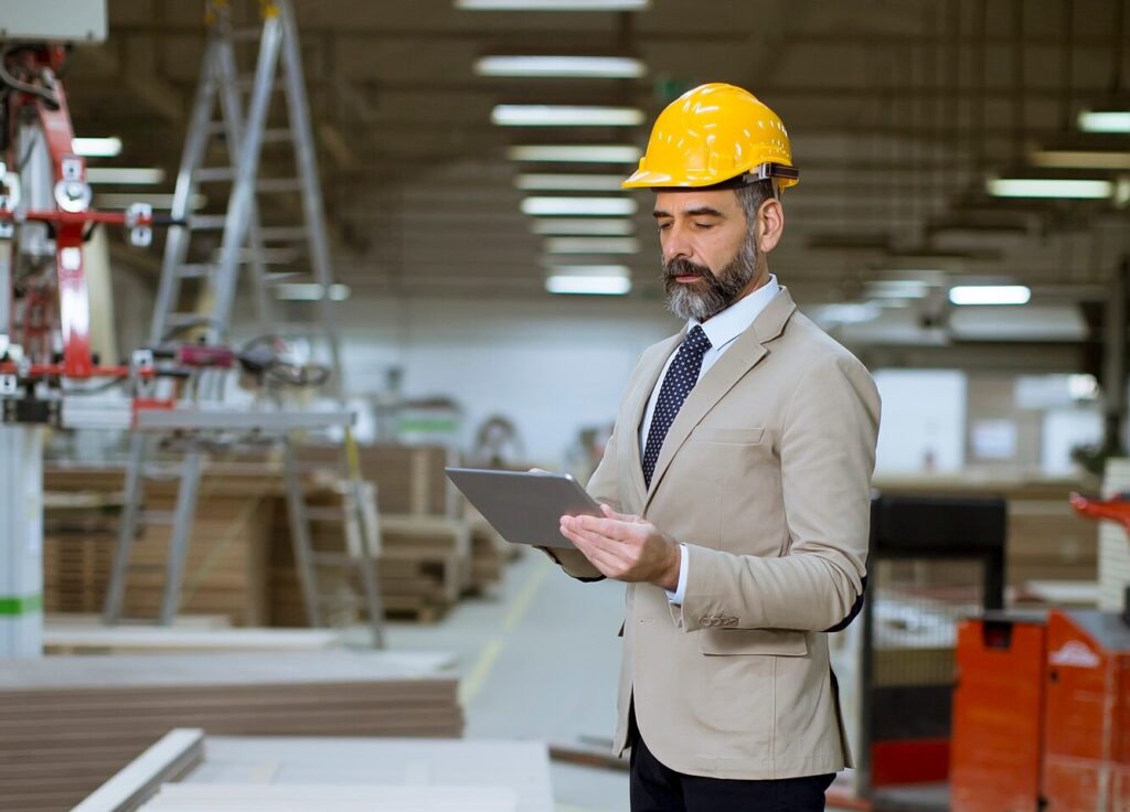 Middle-aged businessman with digital tablet in factory